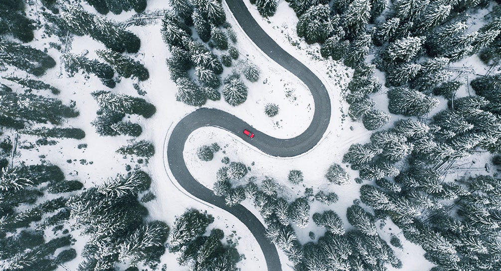 An aerial view of a winding road in the snow.