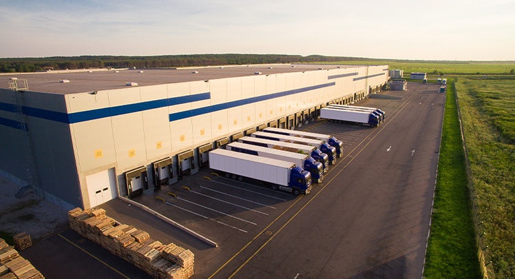 An aerial view of a warehouse with trucks parked in front of it.