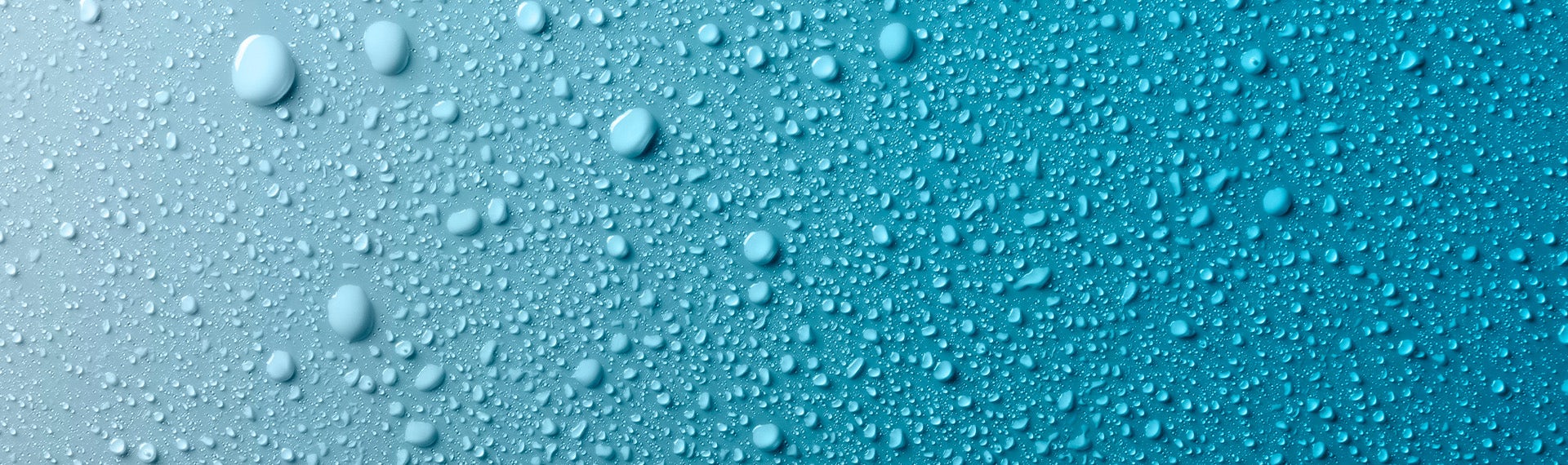 A close up of water droplets on a blue surface.