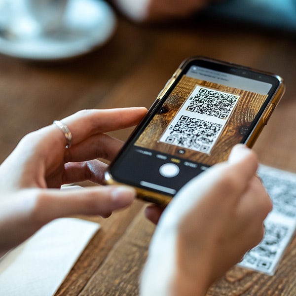 A person using a smartphone to take a photo of a qr code.